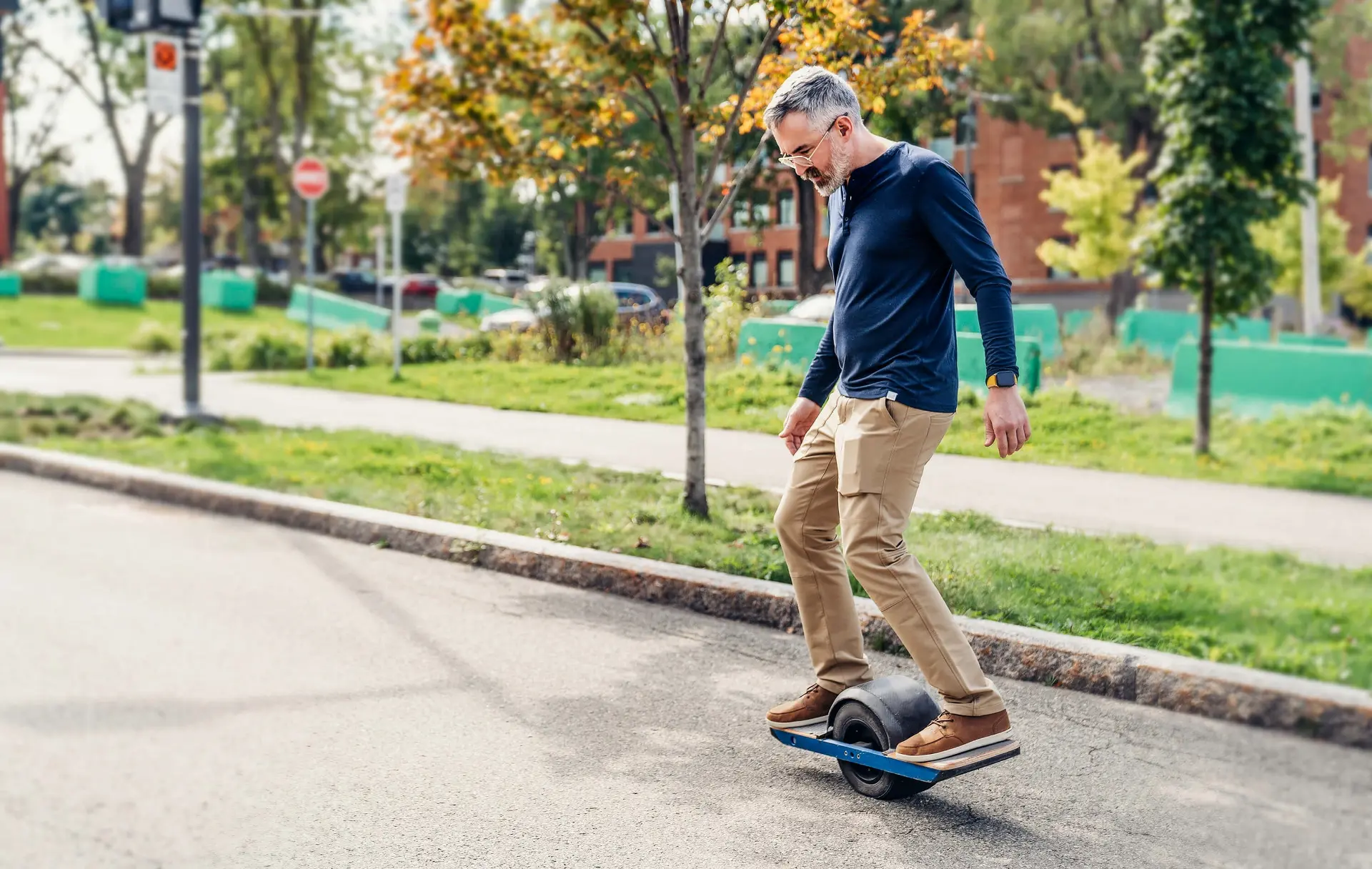 a man rides a onewheel electric skateboard on a street