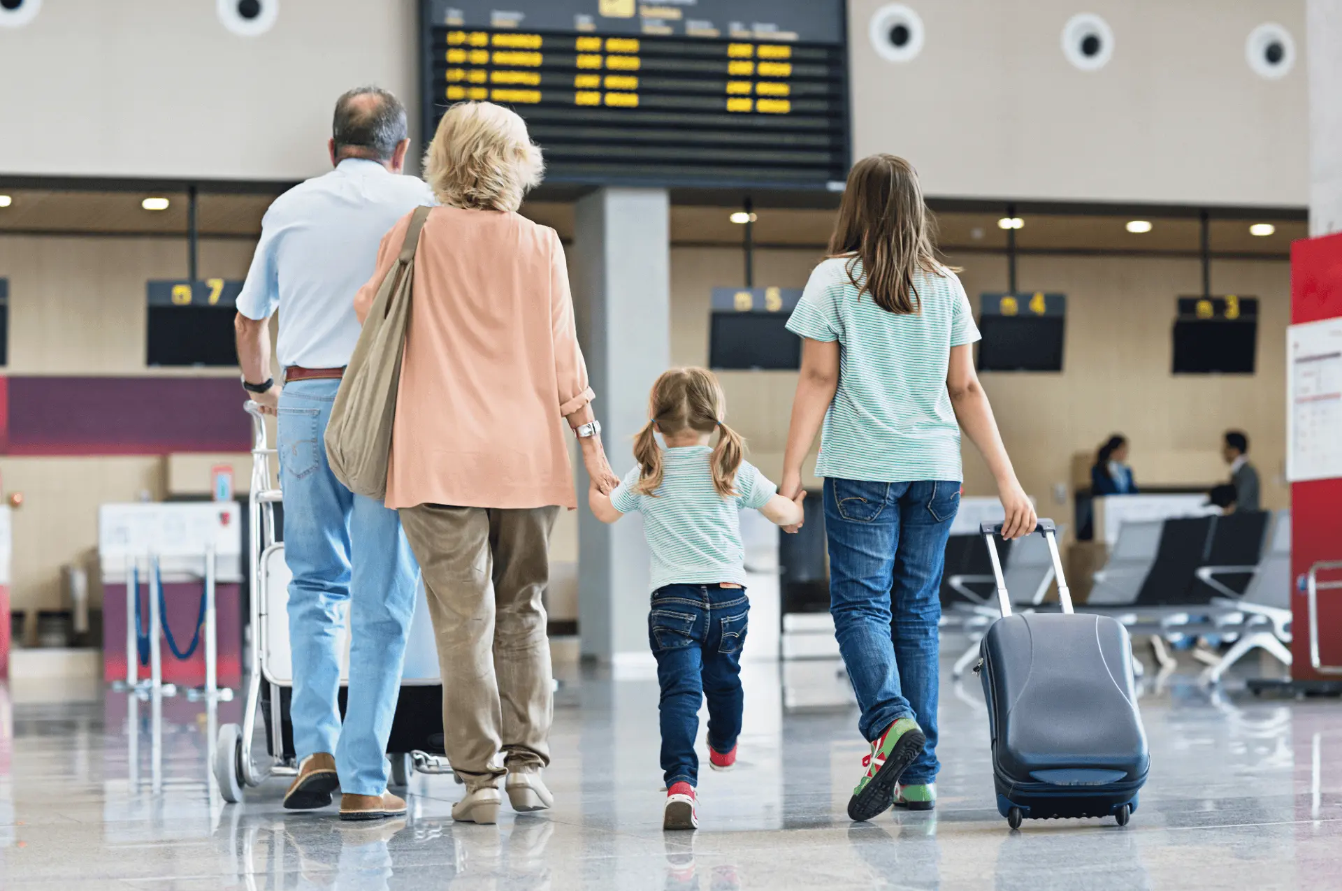 A family walks through the airport to embark on a vacation